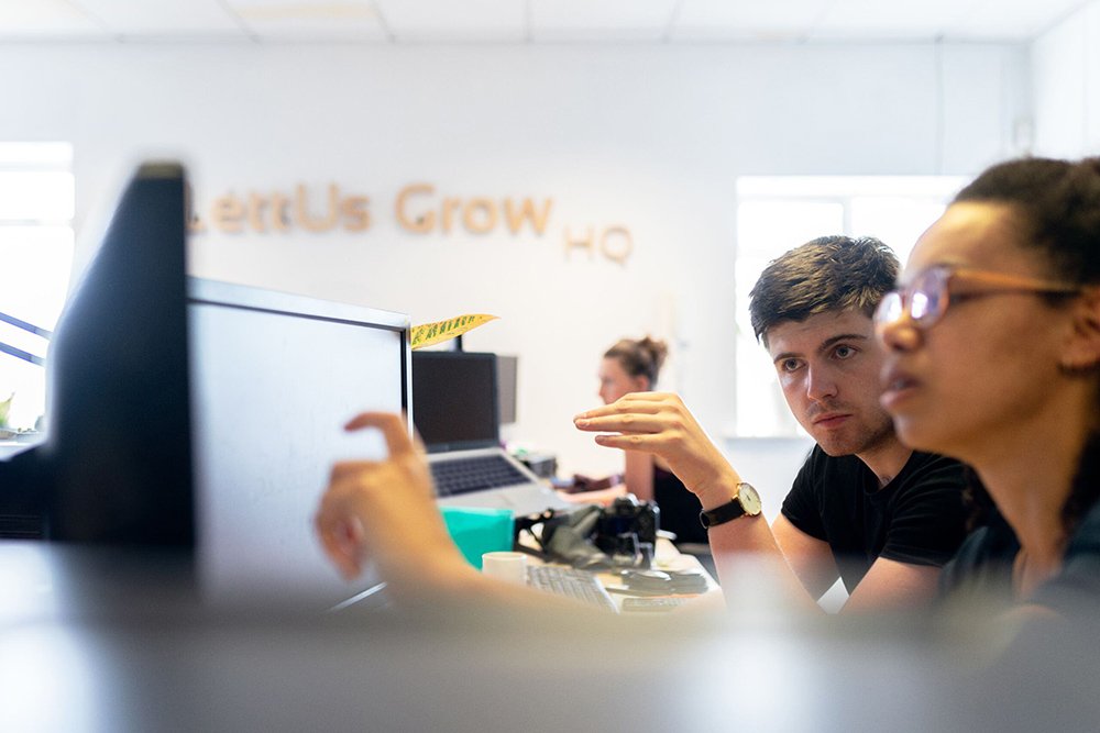 Two people looking at the same monitor