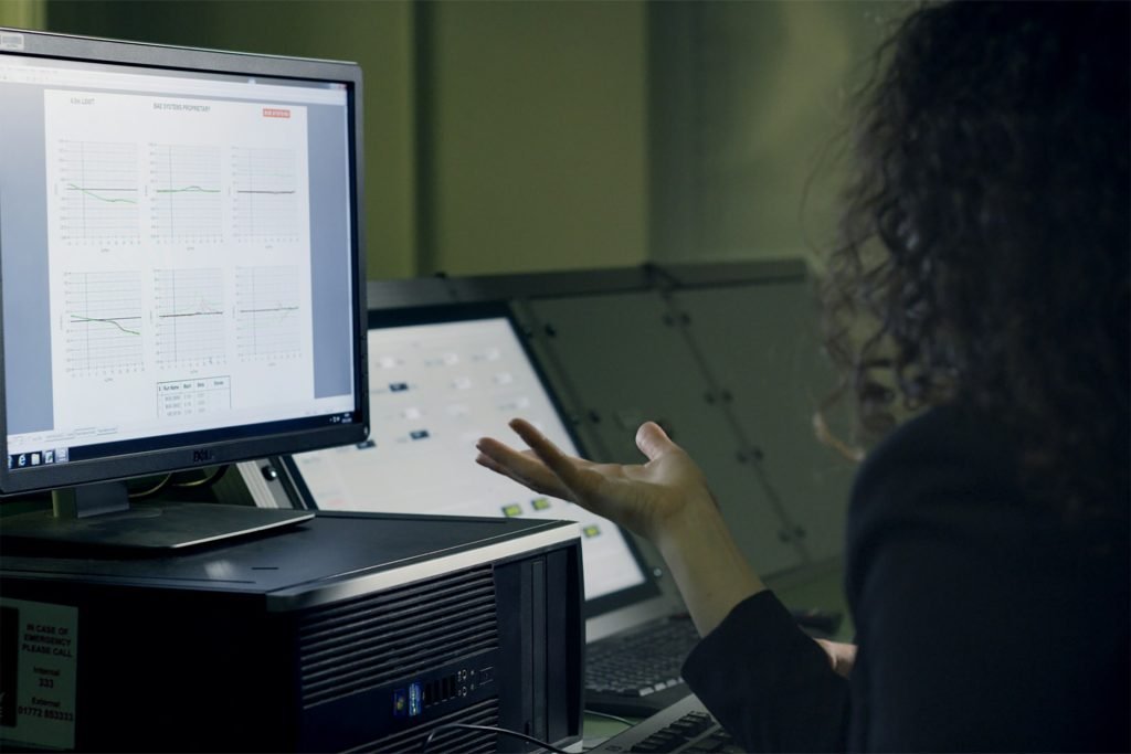 Woman looking at a computer screen displaying graphs
