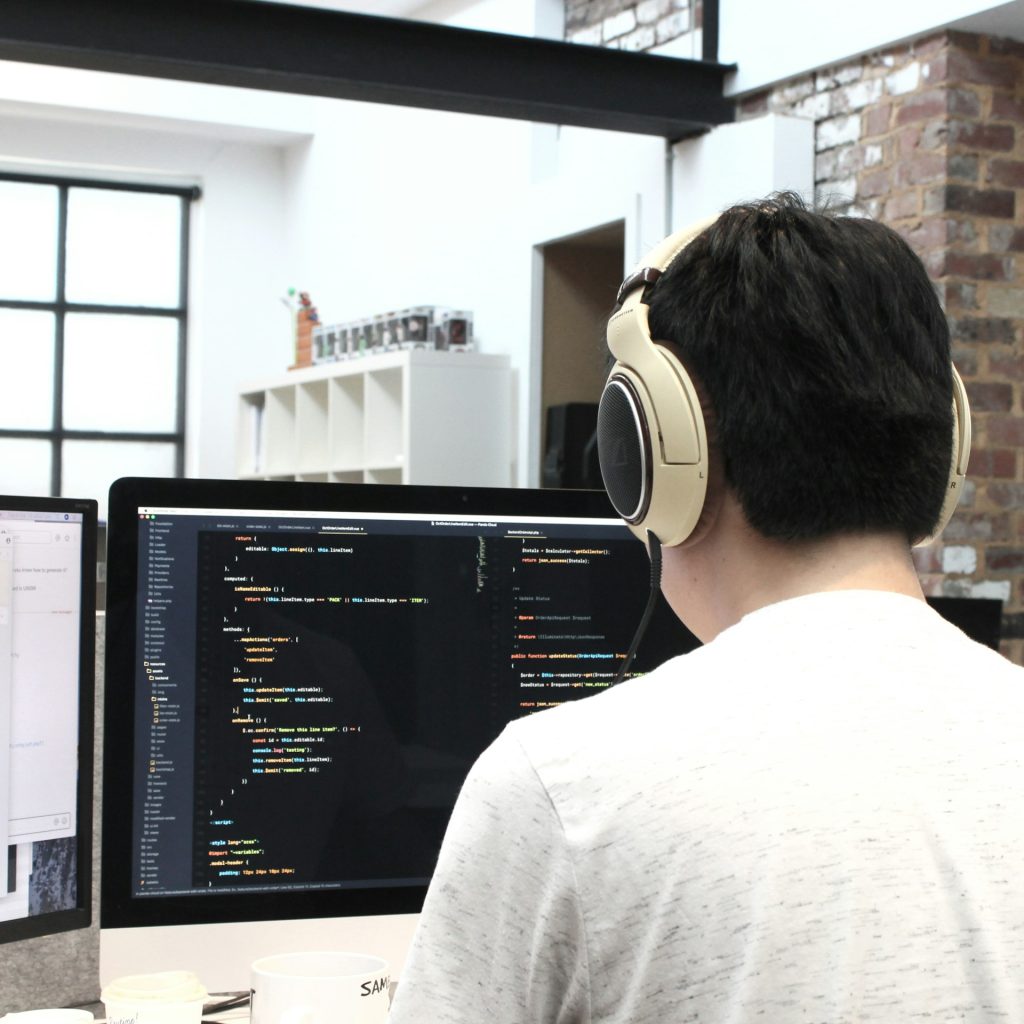 man facing a computer screen displaying code