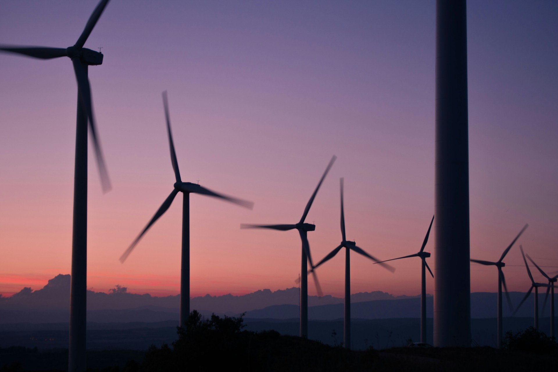 wind turbines against a sunset