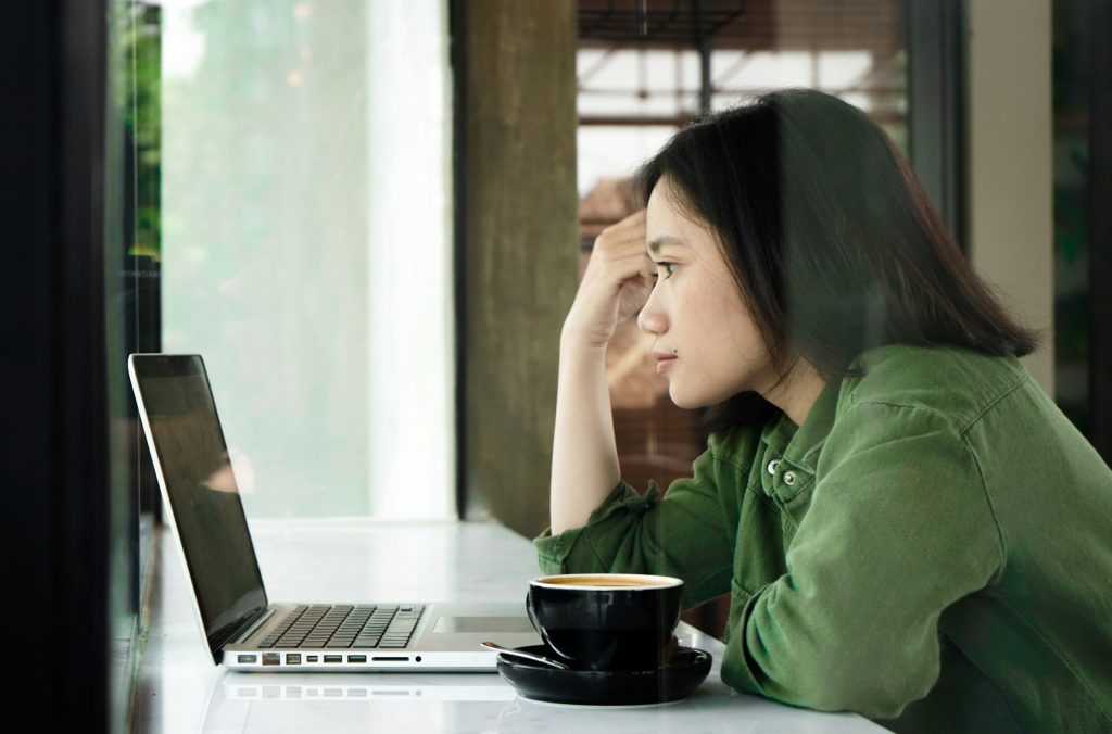 woman at a cafe looking at a laptop