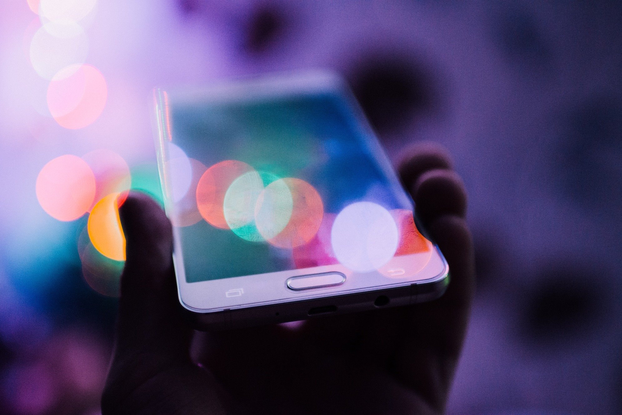a hand holding a neon phone