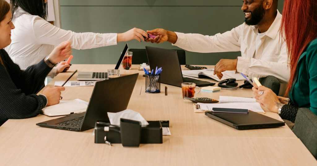 a group of people sat around a desk in an office room