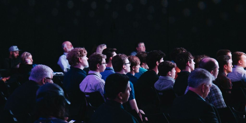crowd of people sitting in chairs at a conference